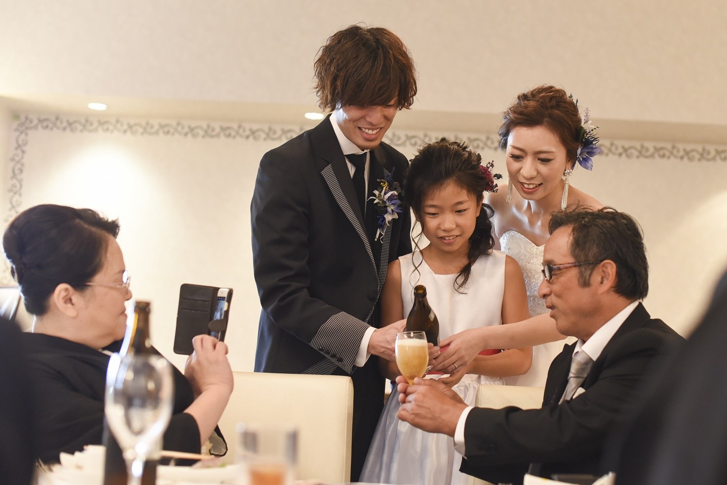香川県の結婚式場シェルエメールで新郎新婦と子供がゲストへお酌